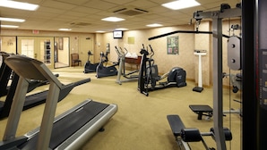 A gym with treadmills, elliptical machines, and weightlifting equipment.