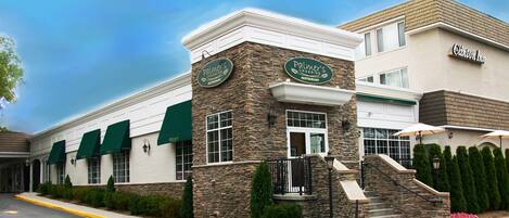 A building with a stone facade and green awnings, labeled "Palmer's Crossing Restaurant."