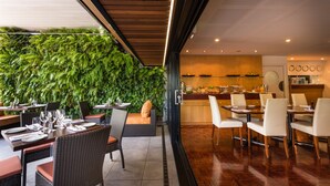 A restaurant with indoor seating, a wooden ceiling, and a green wall.