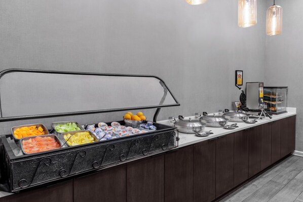 A buffet setup with various food items and condiments.