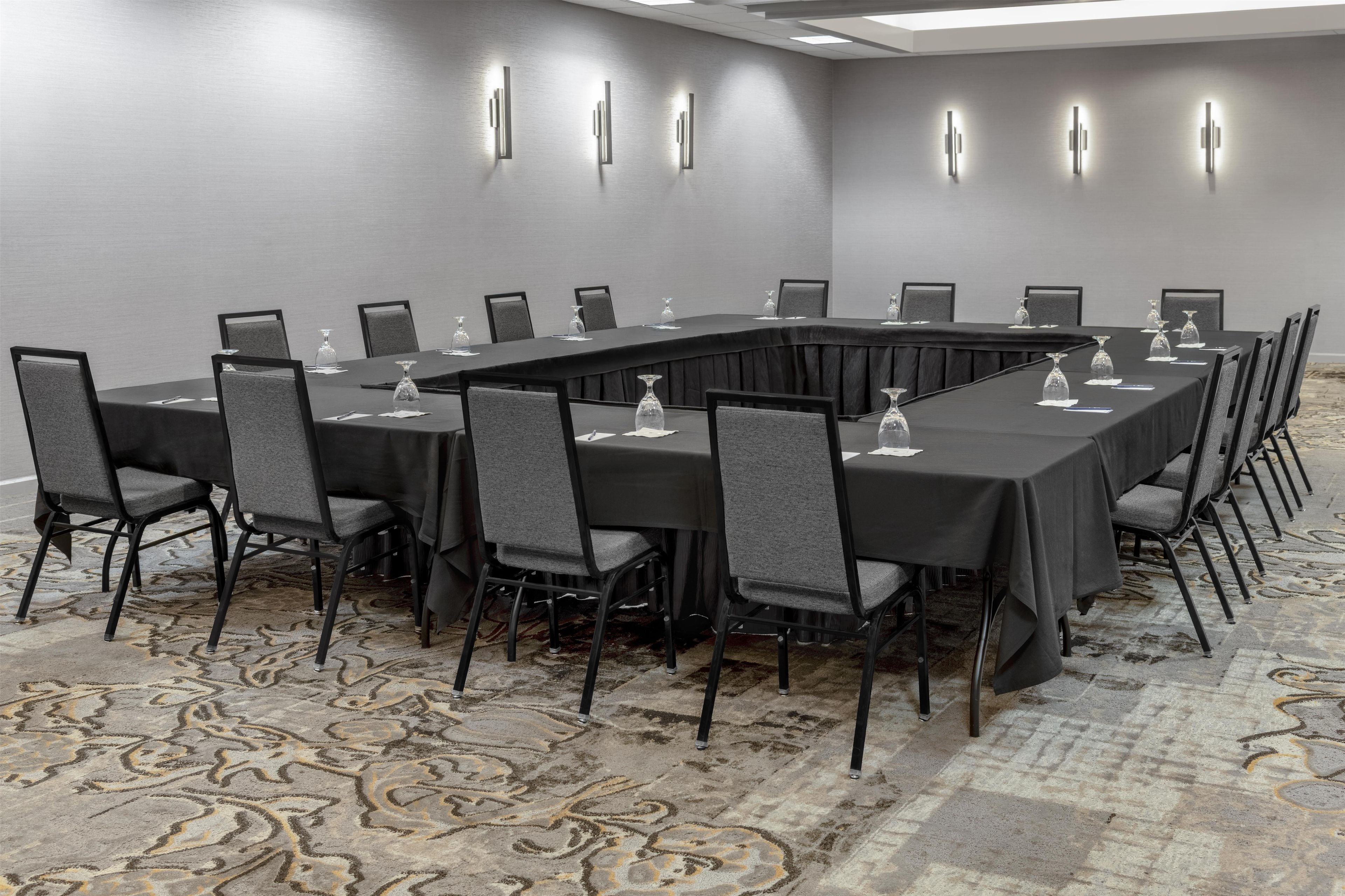 A conference room with a long table, chairs, and glassware.