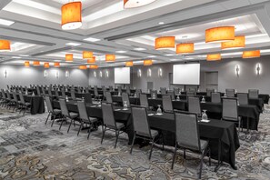 A conference room with rows of tables and chairs, equipped with projectors and screens. - DoubleTree by Hilton Springfield (Springfield)