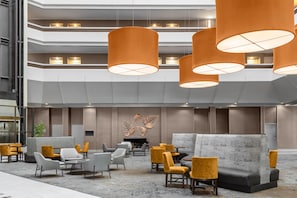 A modern lobby with tiered seating, a fireplace, and decorative wall art.