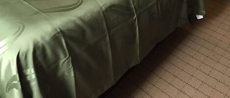Une chambre d’hôtel avec deux lits, une table de chevet avec une lampe et un téléphone fixé au mur.