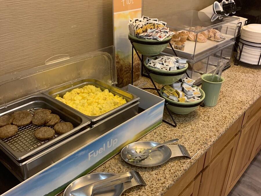 A buffet setup with various food items and utensils.