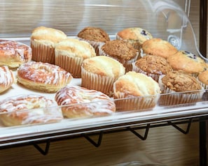 A display case with various baked goods, including muffins and pastries.