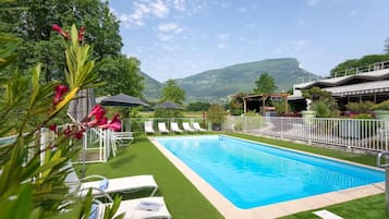 Una piscina al aire libre de temporada, sillones reclinables de piscina