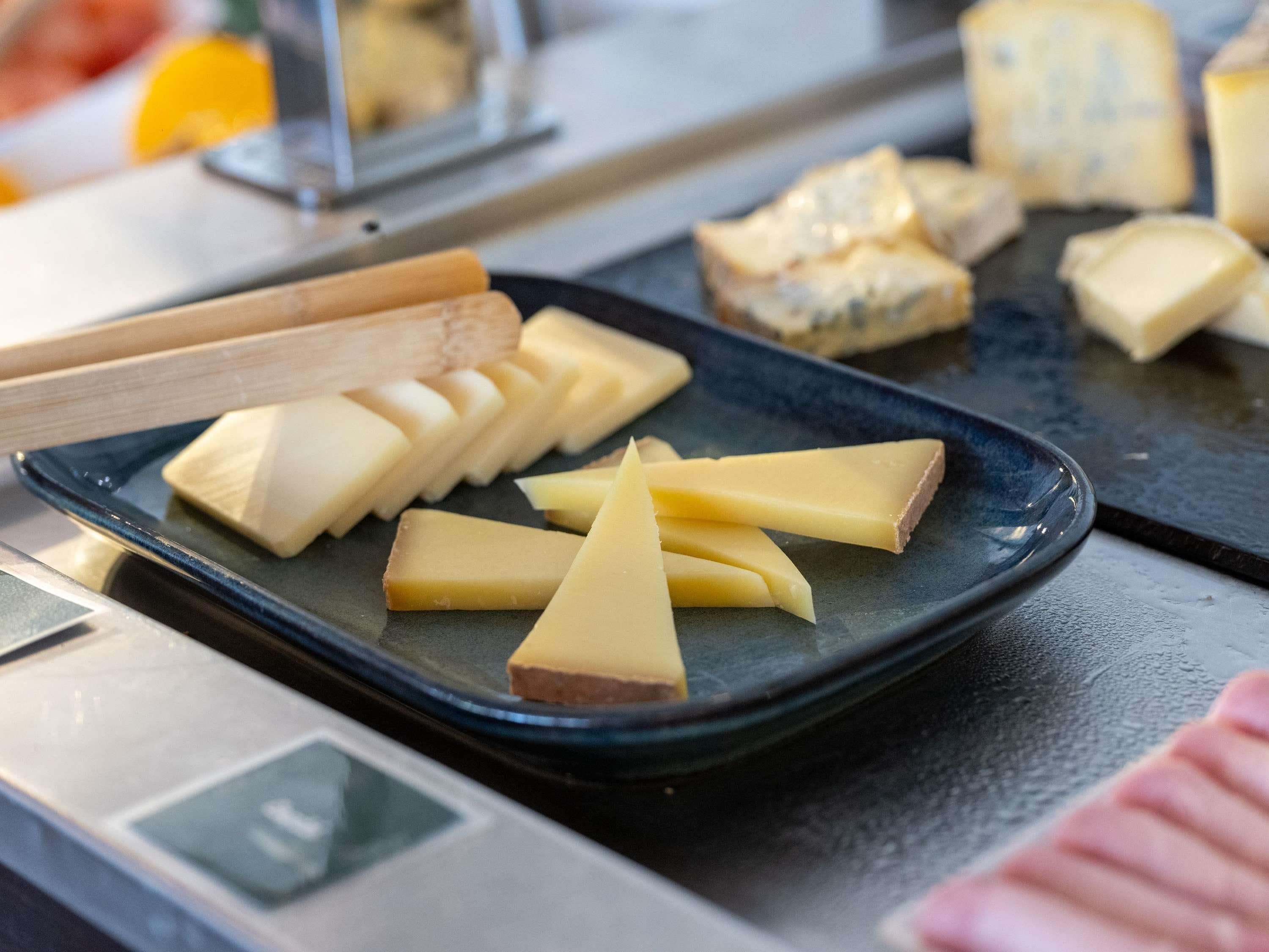 A variety of cheeses on a black plate.
