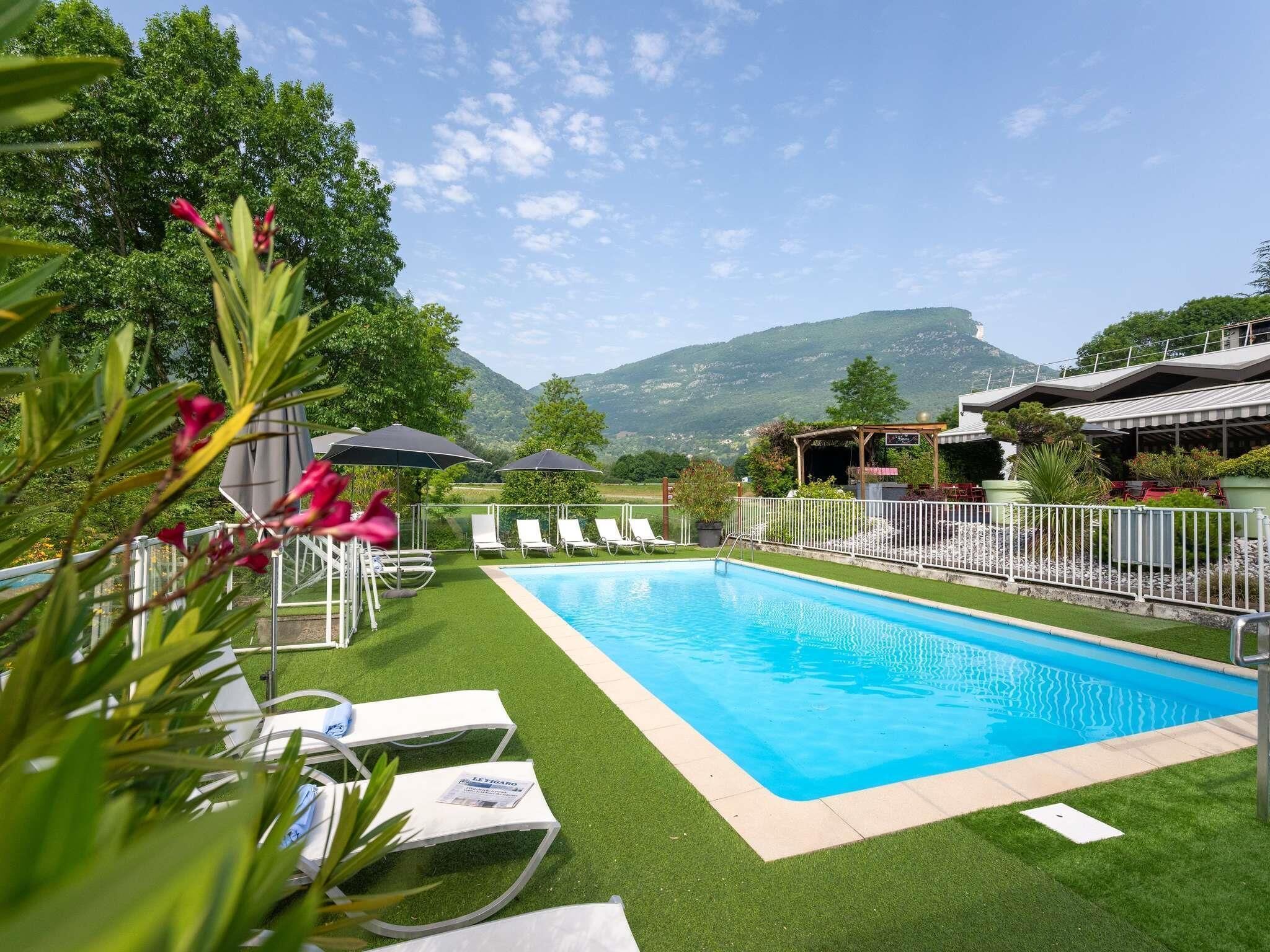 Una piscina al aire libre de temporada, tumbonas