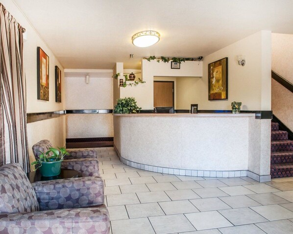 A reception area with a curved counter, cushioned seating, and a staircase.