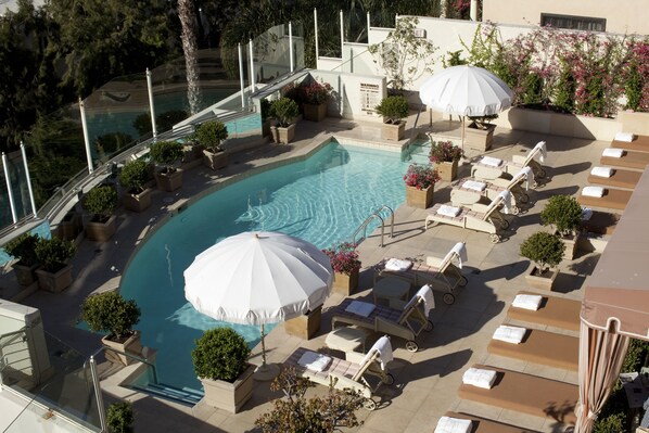 Relax by the pool surrounded by comfortable seating and lush greenery.