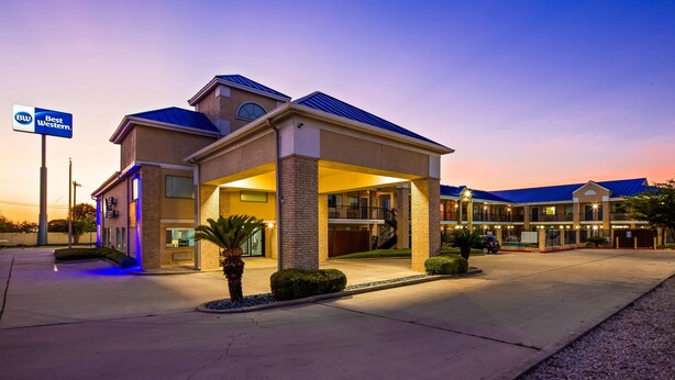 Un hotel dal design moderno, con ingresso coperto e diversi balconi.