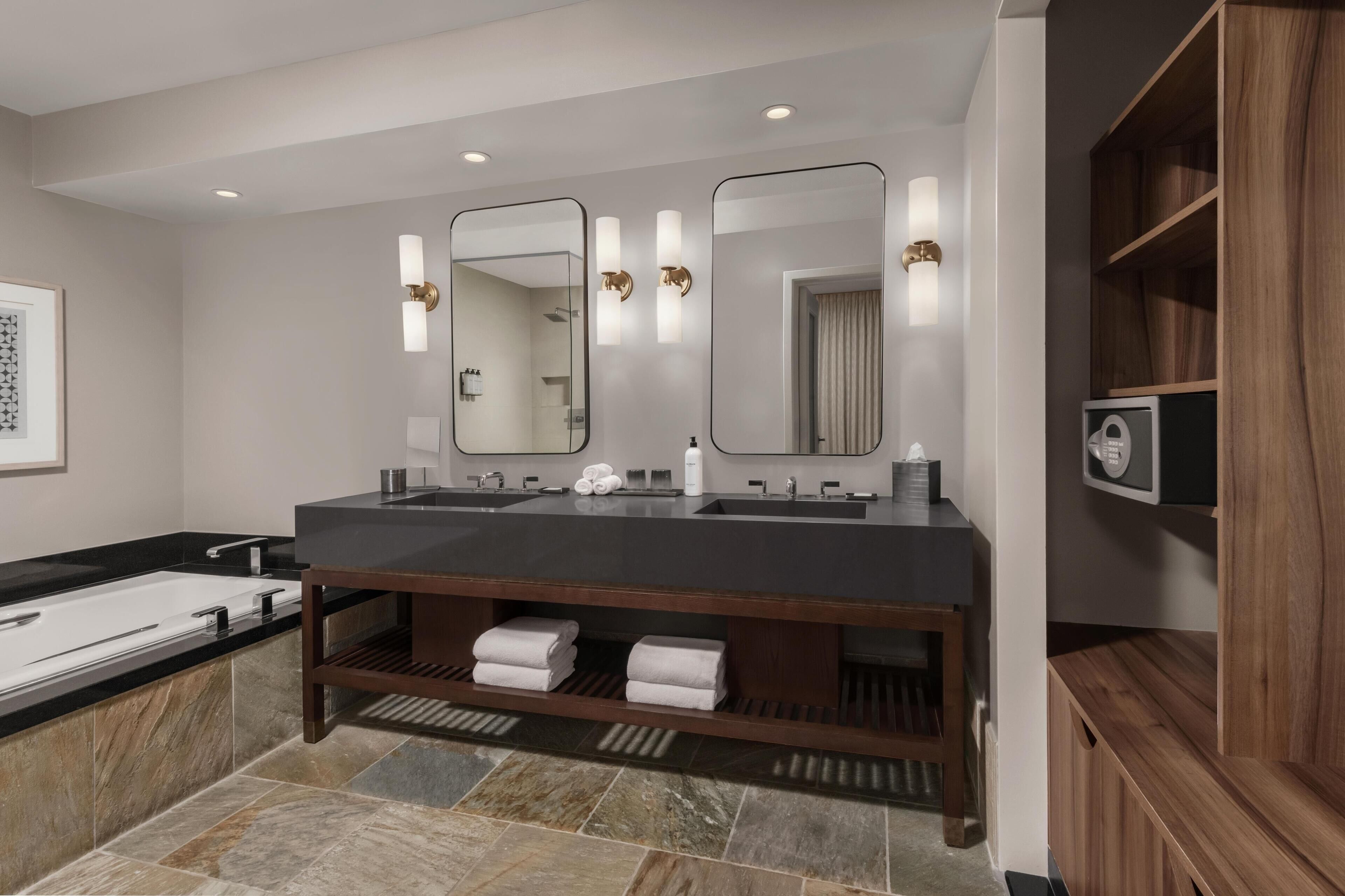 Une salle de bain moderne avec un meuble-lavabo à deux vasques, un grand miroir et une douche intégrée.