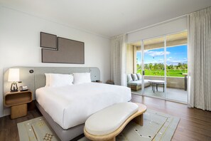 A hotel room with a large bed, a bedside table with a lamp, a view of a balcony with outdoor furniture, and a large window with curtains. - Grand Hyatt Indian Wells Resort & Villas (Indian Wells)
