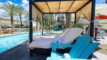 Relax by the pool surrounded by lush palm trees and tropical vegetation.