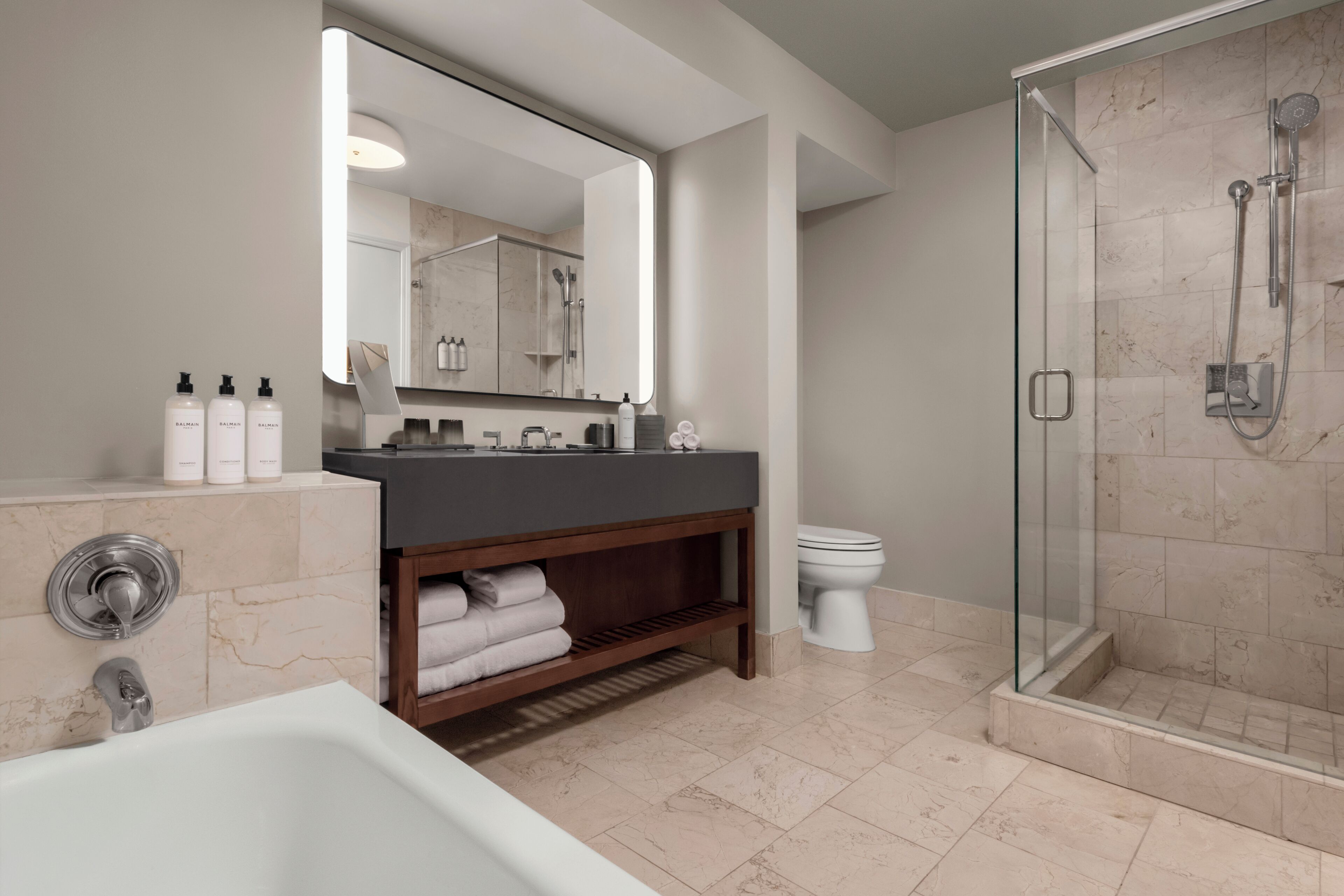 Un baño moderno con bañera, ducha, tocador con espejo y retrete.