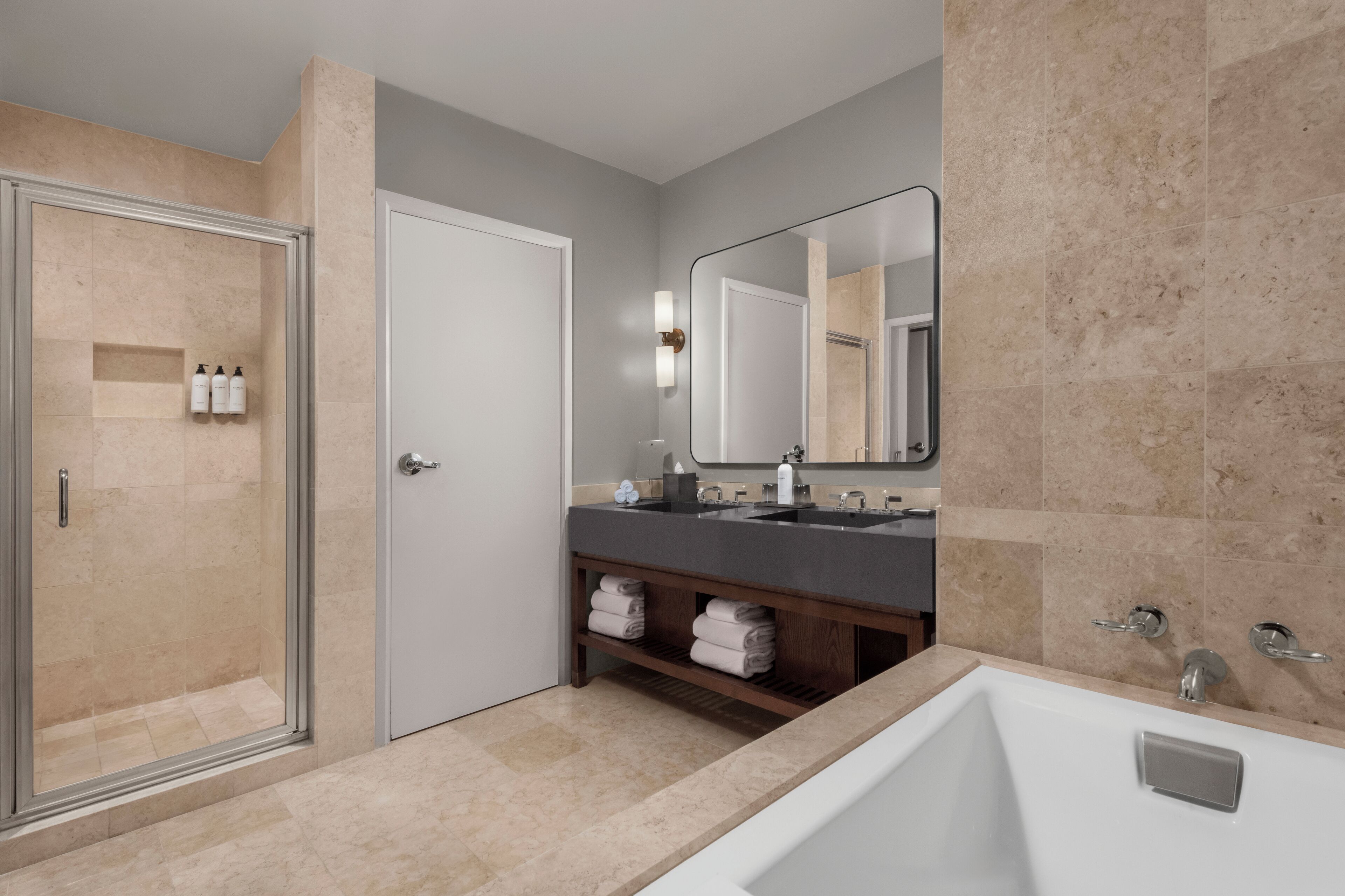 A modern bathroom with a glass-enclosed shower, a double sink vanity, and a large mirror.