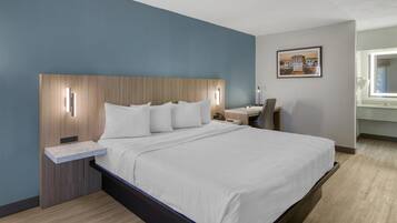 Una habitación de hotel moderna con una cama grande, un escritorio y una silla.