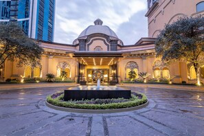 A grand hotel entrance with a central fountain, surrounded by a landscaped garden and a paved courtyard. - Quinta Real Monterrey (San Pedro Garza García)
