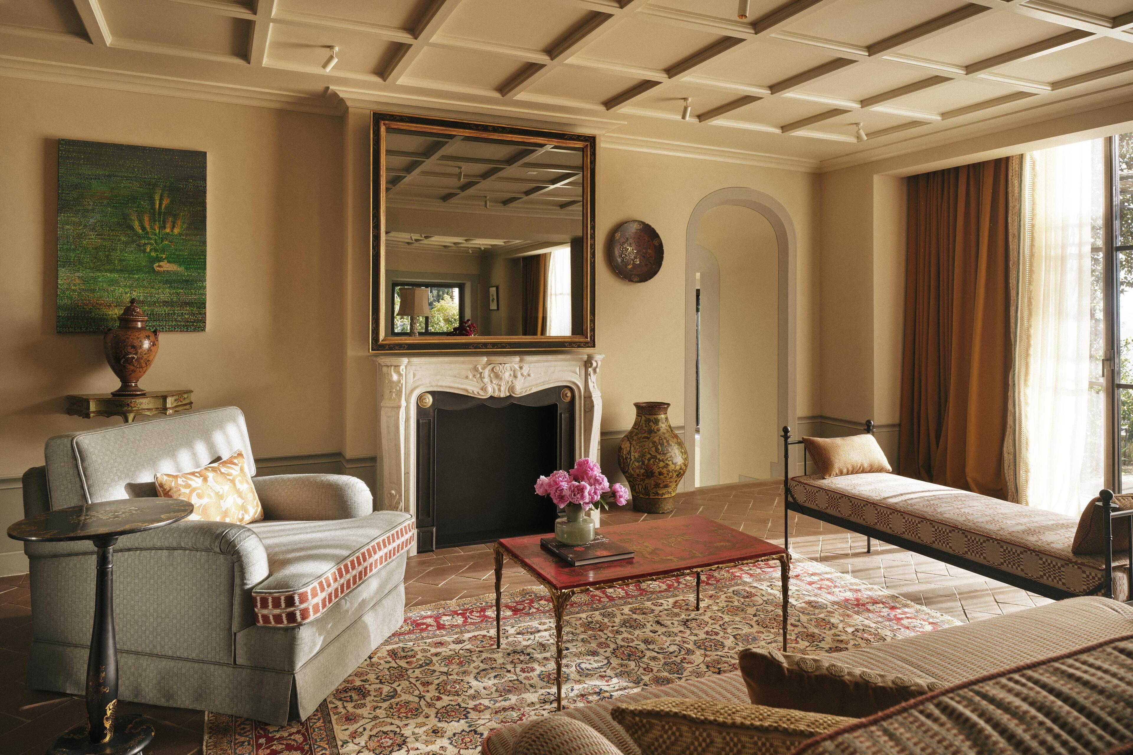 A living room with a fireplace, a sofa, a coffee table, and a large mirror.