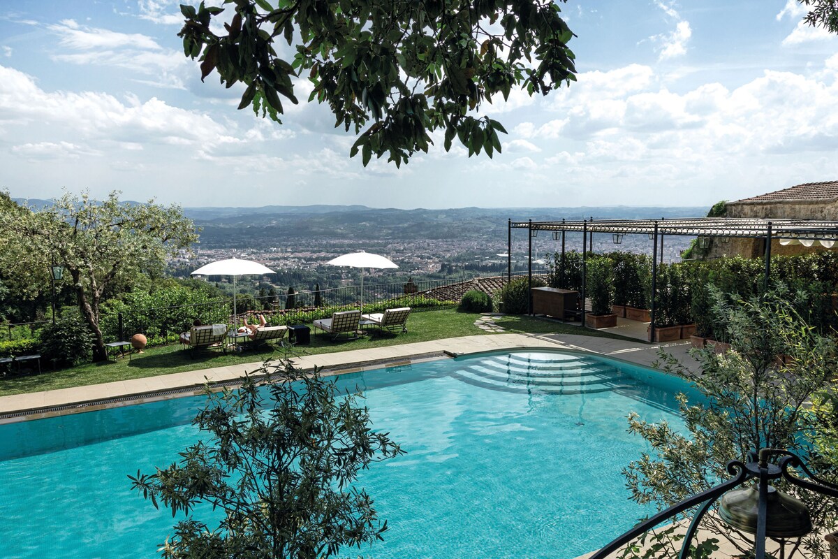 Una piscina al aire libre, sillones reclinables de piscina