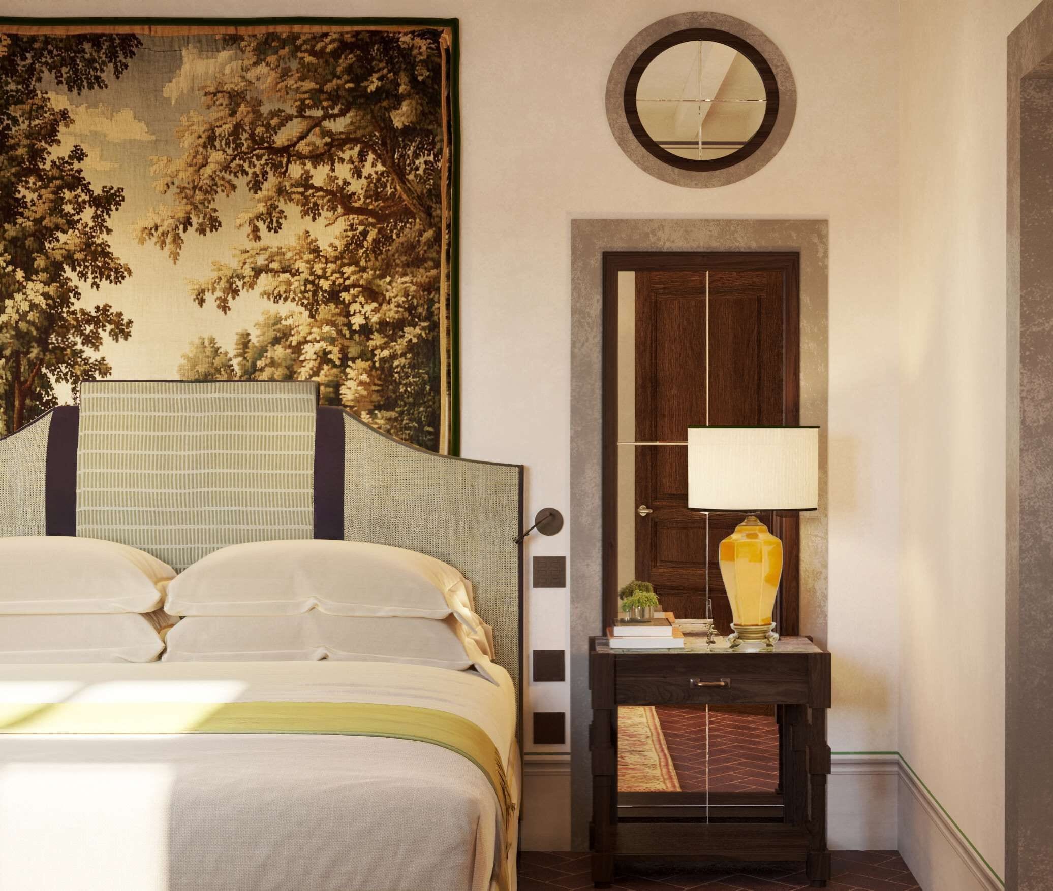 A hotel room with a bed, a nightstand with a lamp, a painting, and a door.
