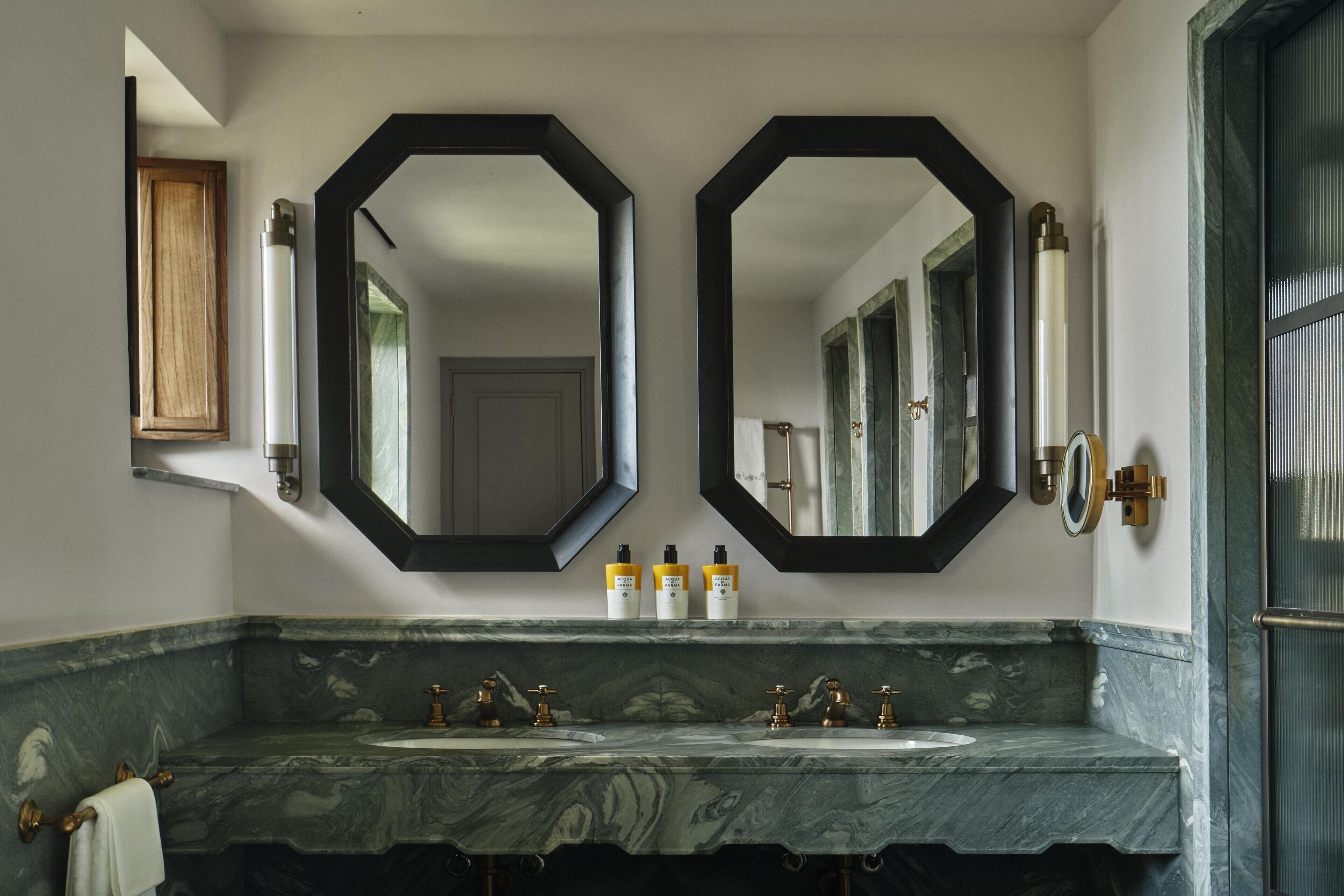 A bathroom with two sinks, a large mirror, and a wooden cabinet.