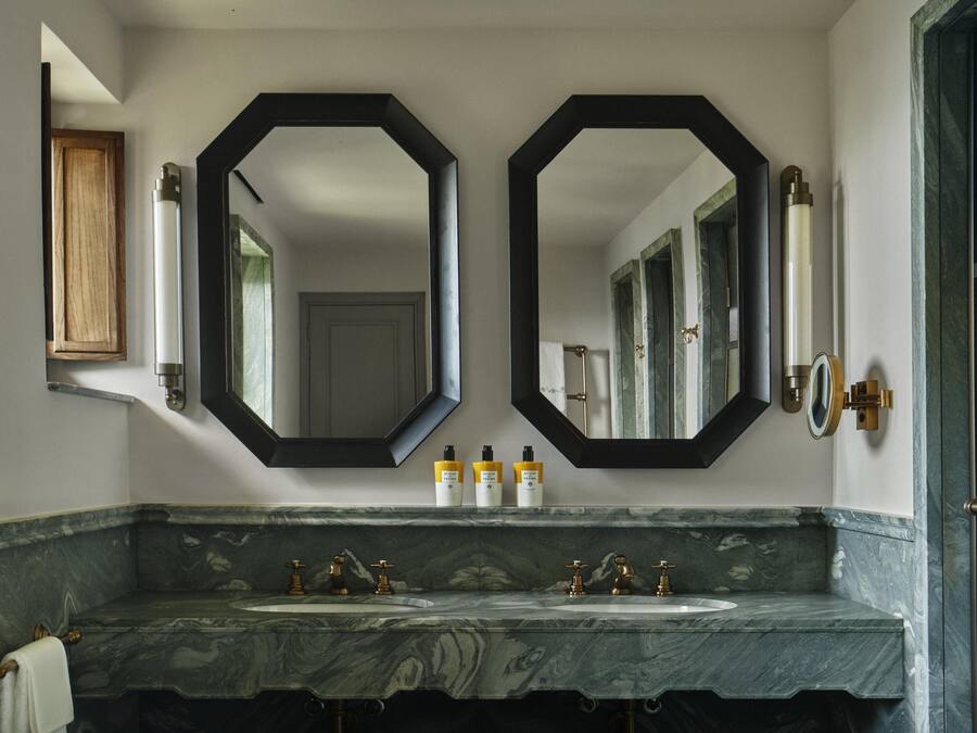 Un baño con dos lavamanos, un espejo grande y un armario de madera.