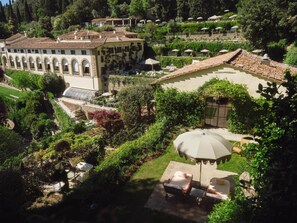 A villa with a patio, outdoor seating, and a garden. - Villa San Michele, A Belmond Hotel, Florence (Fiesole)