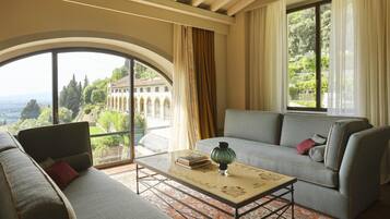Una habitación con sofá, una mesita de centro y vistas a un edificio con arcos.