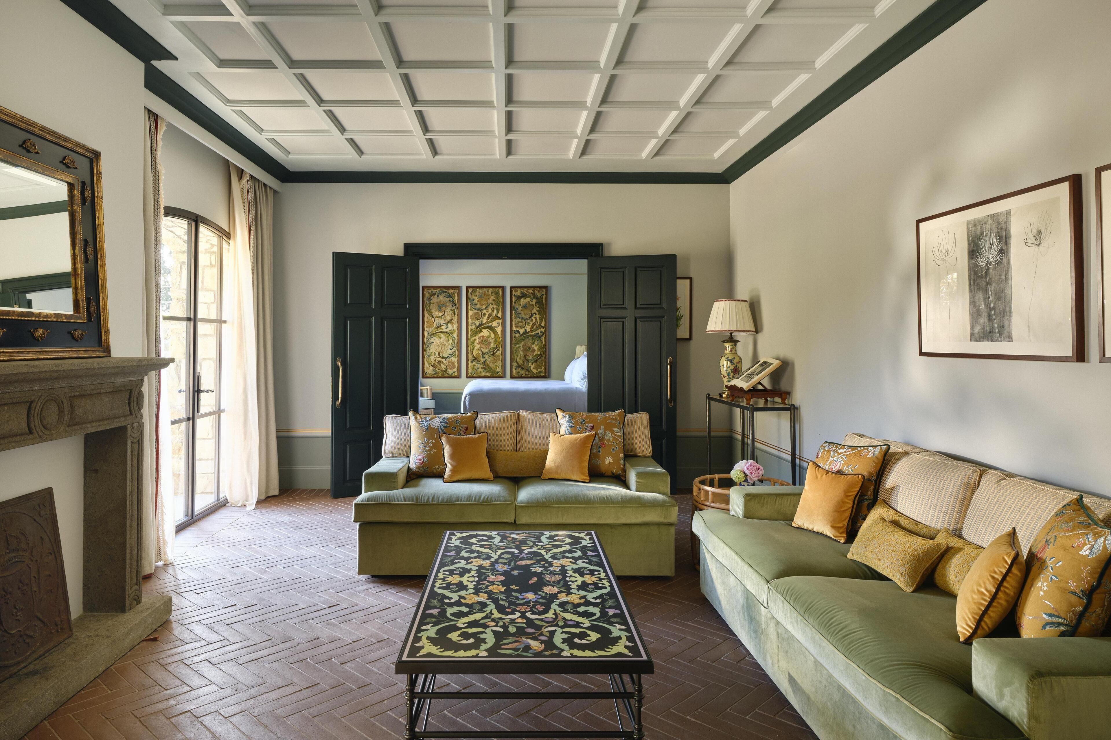 Uma sala de estar com sofá, mesa de centro, lareira e uma janela grande.