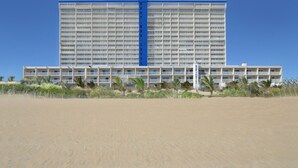 A large hotel with multiple floors and balconies, situated on a sandy beach. - Carousel Resort Hotel & Condominiums (Ocean City)