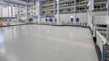 A large indoor swimming pool with multiple levels of balconies and railings.
