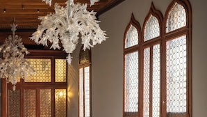 A room with a chandelier, wooden furniture, and large stained glass windows. - Hotel Gabrielli - Starhotels Collezione  (Venice)
