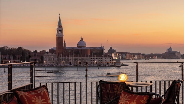 A terrace with outdoor seating and a view of a historic building across the water. - Hotel Gabrielli - Starhotels Collezione  (Venice)