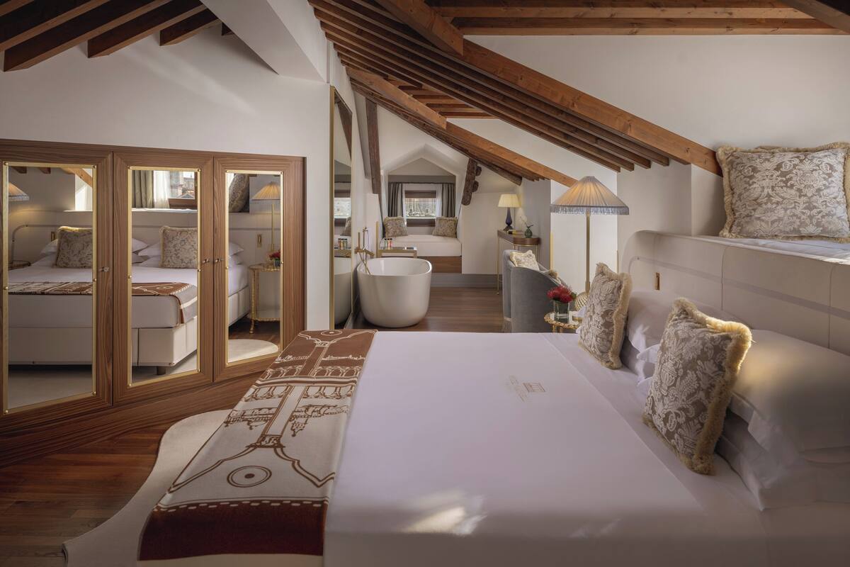Une chambre spacieuse avec un grand lit, un coin salon avec un canapé et une salle de bain séparée.