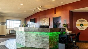 A reception area with a stone counter, a desk with a computer, and a wall-mounted sign for Northwest Missouri State University Bearcats.