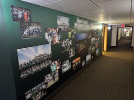 A hallway with a wall displaying photos of Northwest Missouri State Bearcats football team.