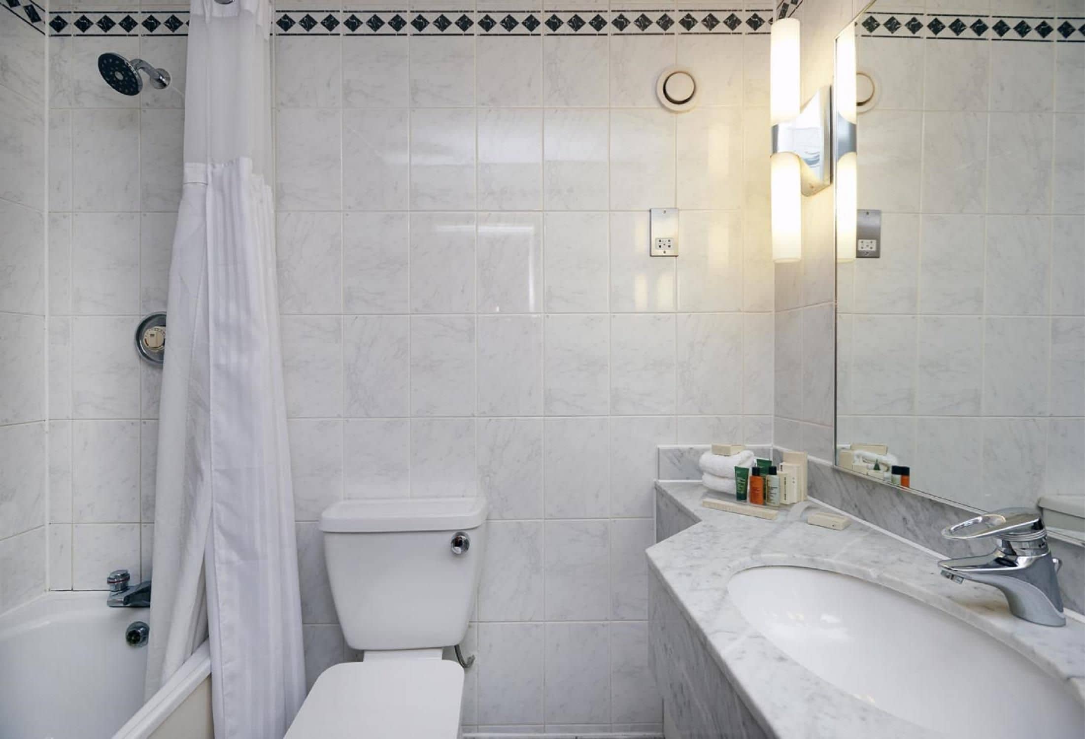 A bathroom with a shower, toilet, and sink.