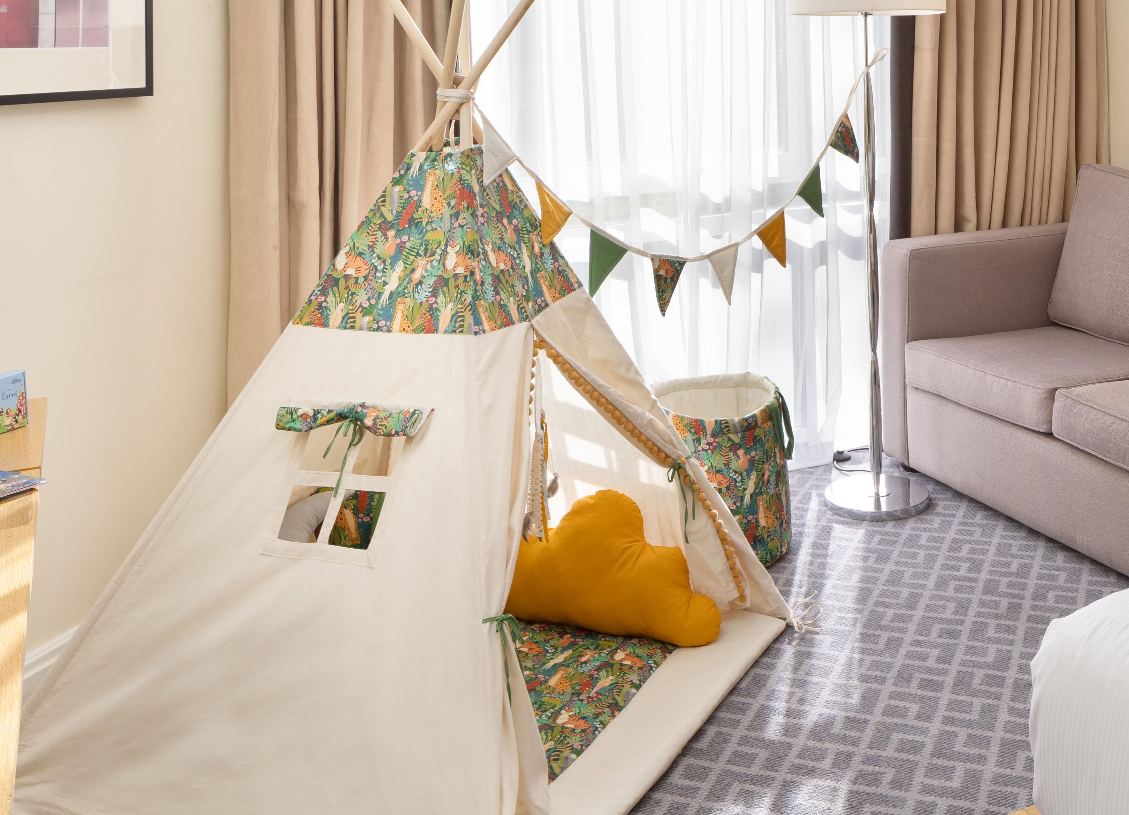 A cozy room with a white tent-like structure, a beige sofa, and a patterned rug.