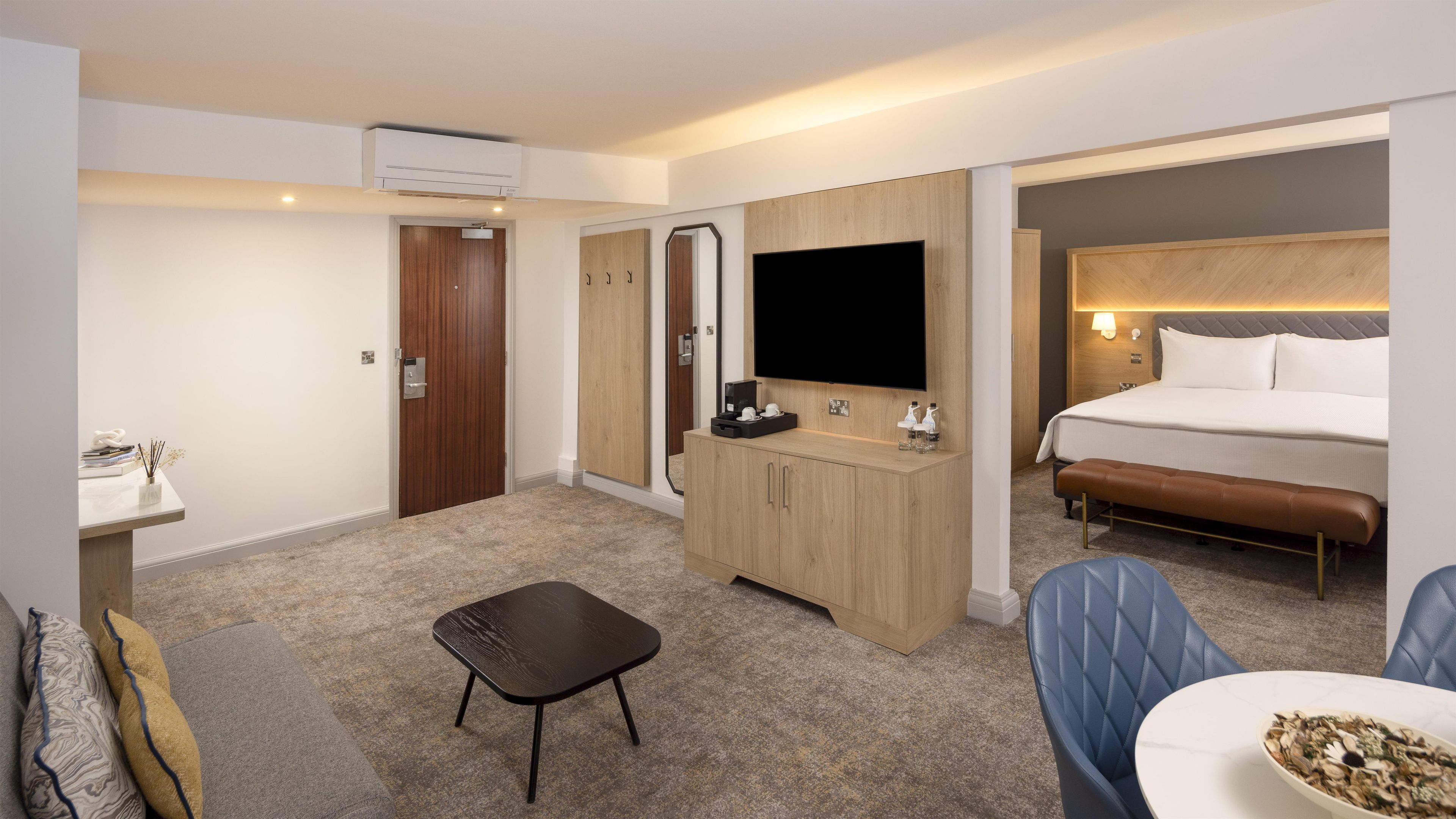 Une chambre d’hôtel comprenant un lit, une télévision, un bureau et un coin salon.