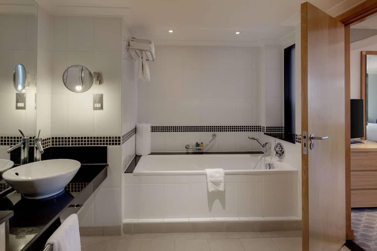 A modern bathroom with a bathtub, a sink, and a vanity.