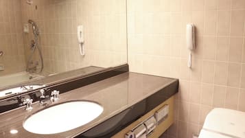 Un baño con un espejo grande, un lavabo, un inodoro y una ducha.