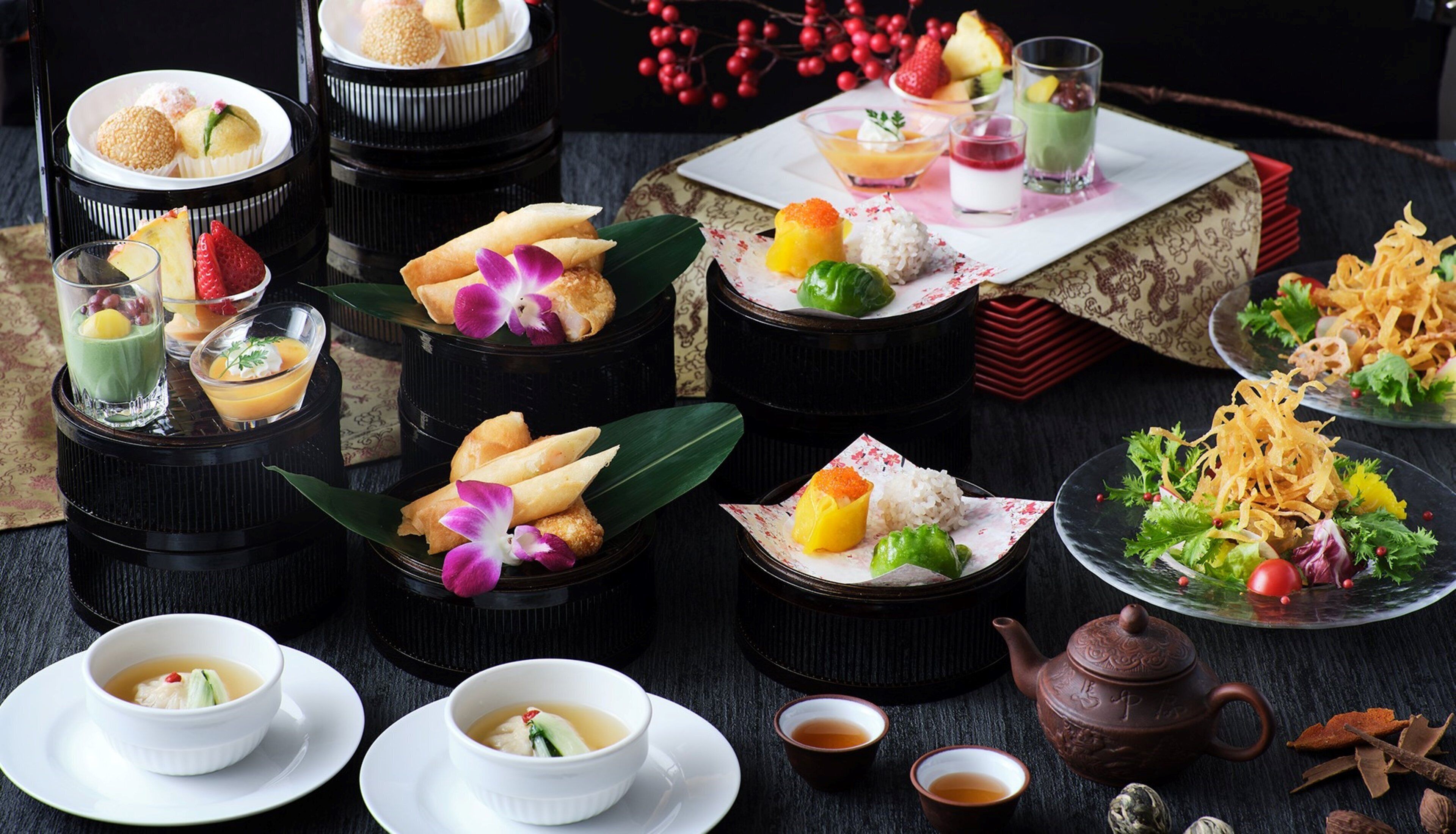 A variety of traditional Asian desserts and beverages arranged on a table.