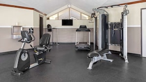 A gym with cardio equipment, a bench press, and a squat rack.
