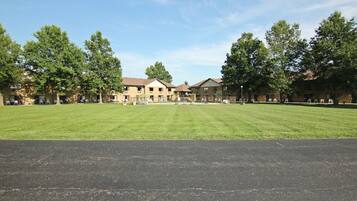 A large, open grassy area with a building in the background.