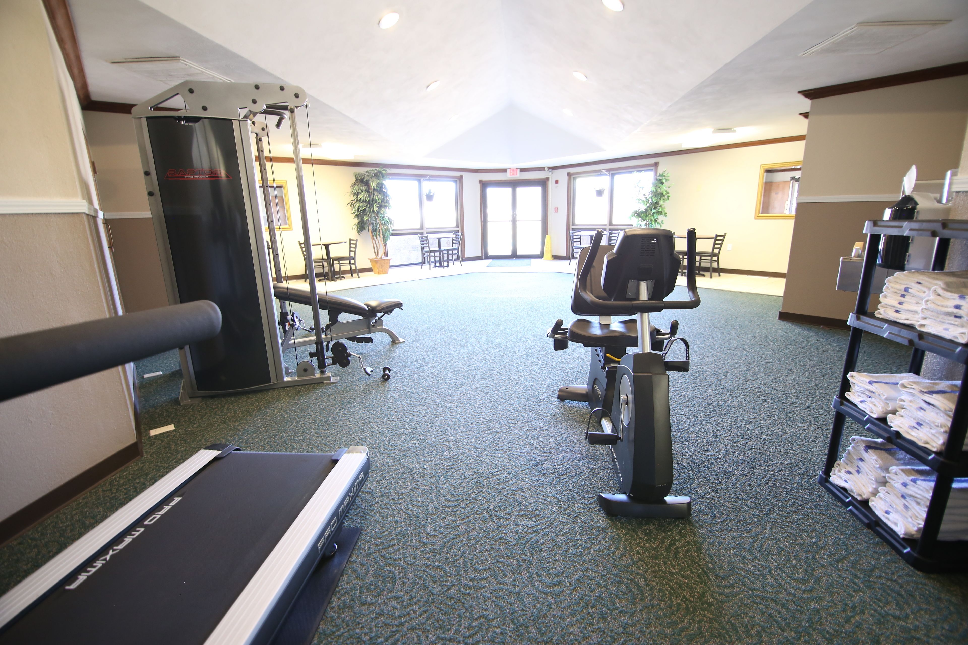 A gym with exercise equipment, a treadmill, and a water station.