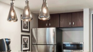 A modern kitchen with a central island, stainless steel appliances, and pendant lighting. - Houston Marriott Medical Center/Museum District (Houston)