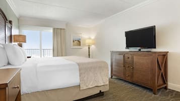 Una habitación de hotel con una cama grande, un televisor sobre un mueble de madera y una ventana con cortinas.
