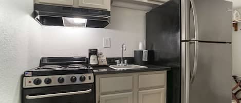 A compact kitchen with a stove, oven, and refrigerator.